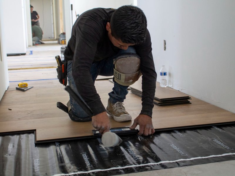 Flooring installer measuring flooring level during an installation in St George, Utah